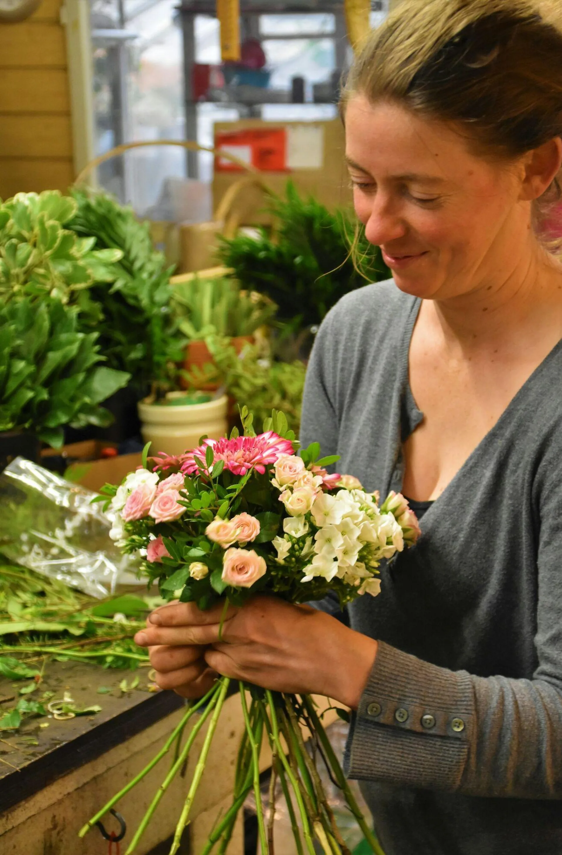 Floristin bindet einen bunten Blumenstrauß in ihrem Laden
